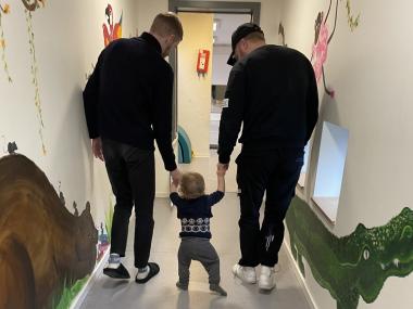 Barn går med to voksne